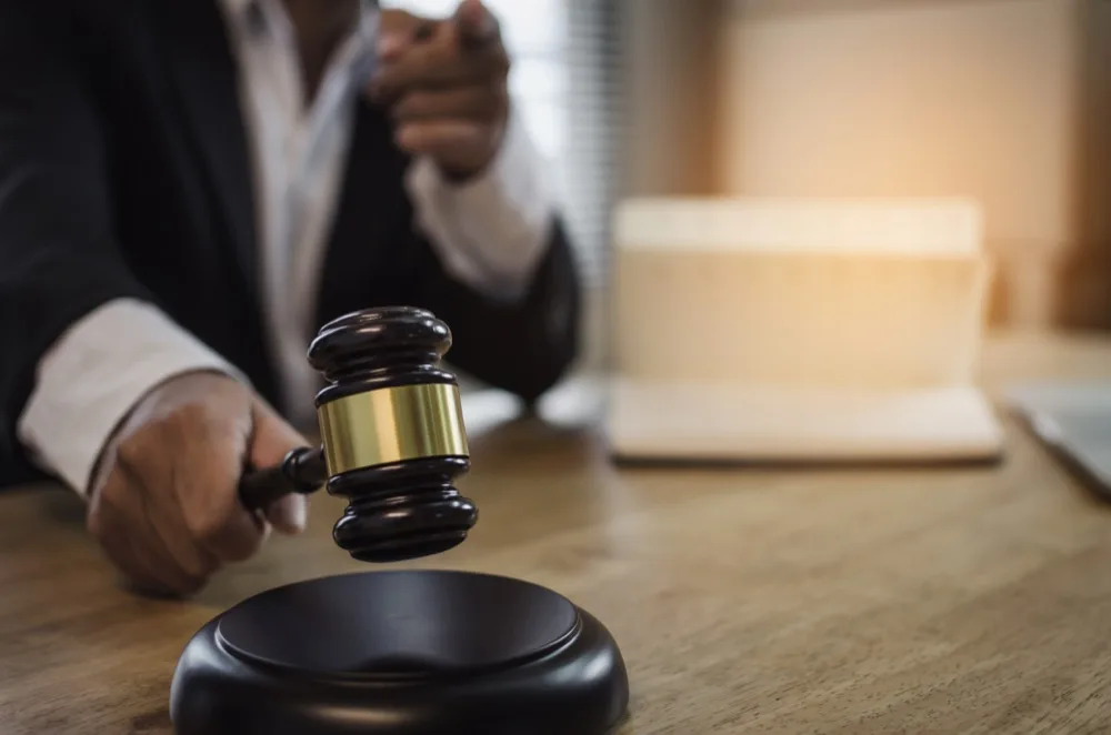 Attorney and client reviewing documents with the scales of justice on the desk