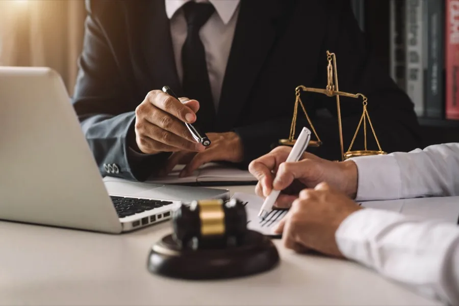 Attorney reviewing documents with a gavel and scales of justice